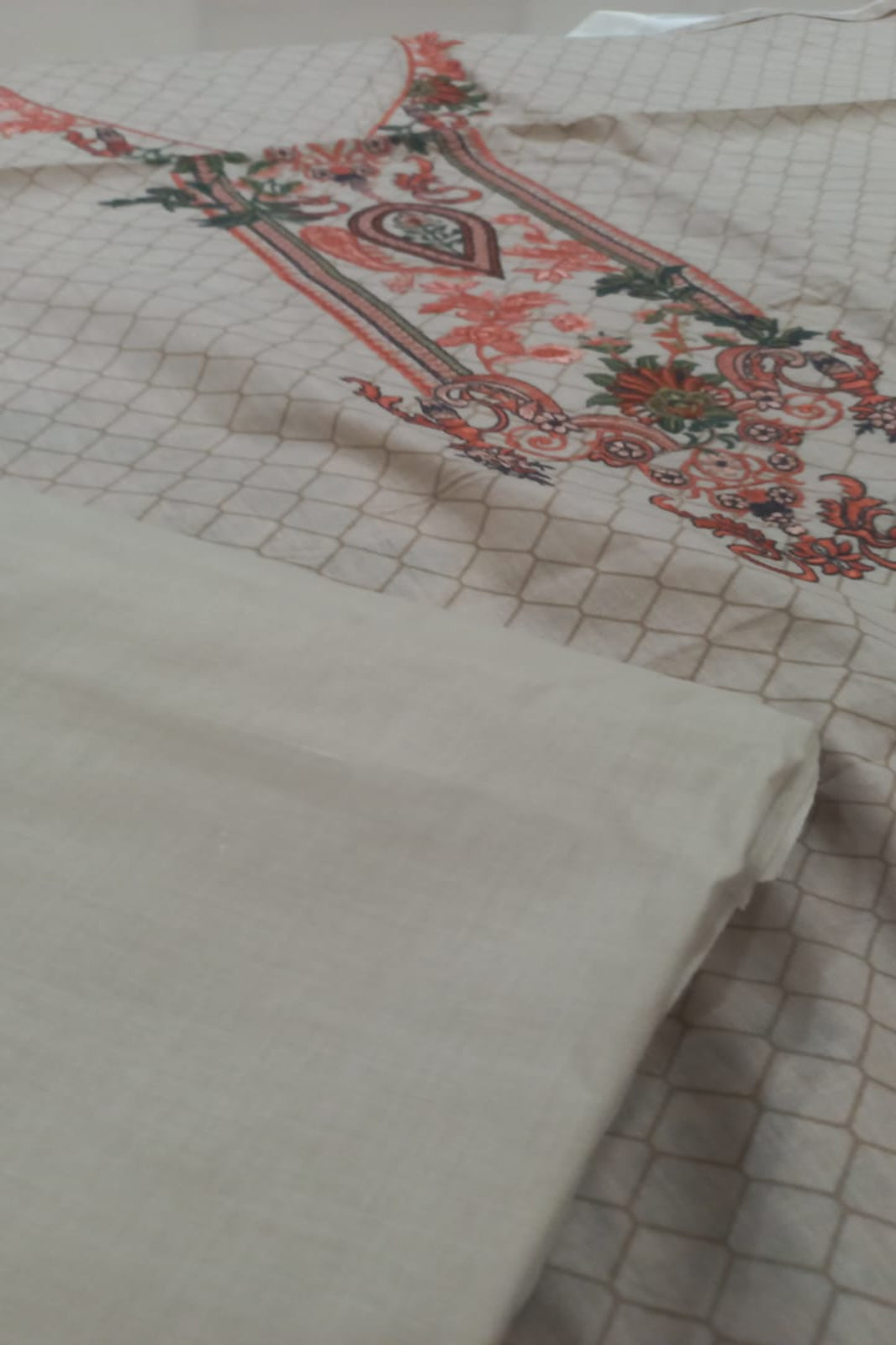 Textile with intricate patterns and embroidery on a beige background