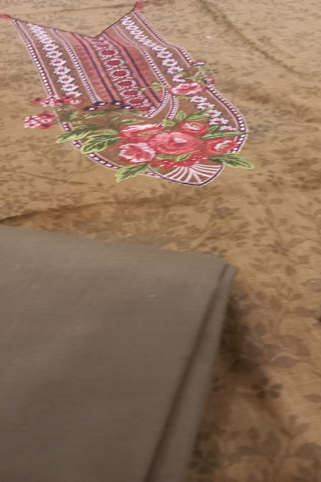 Embroidered fabric with floral design on a brown background