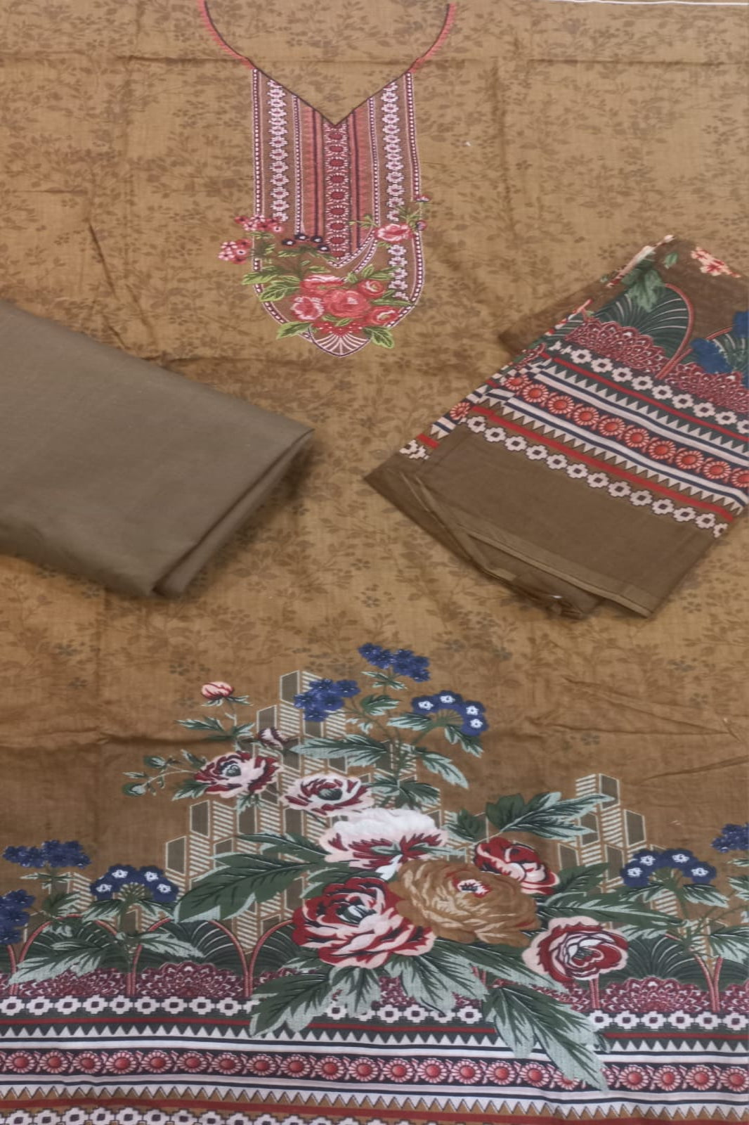 Embroidered fabric with floral and geometric patterns on a brown background