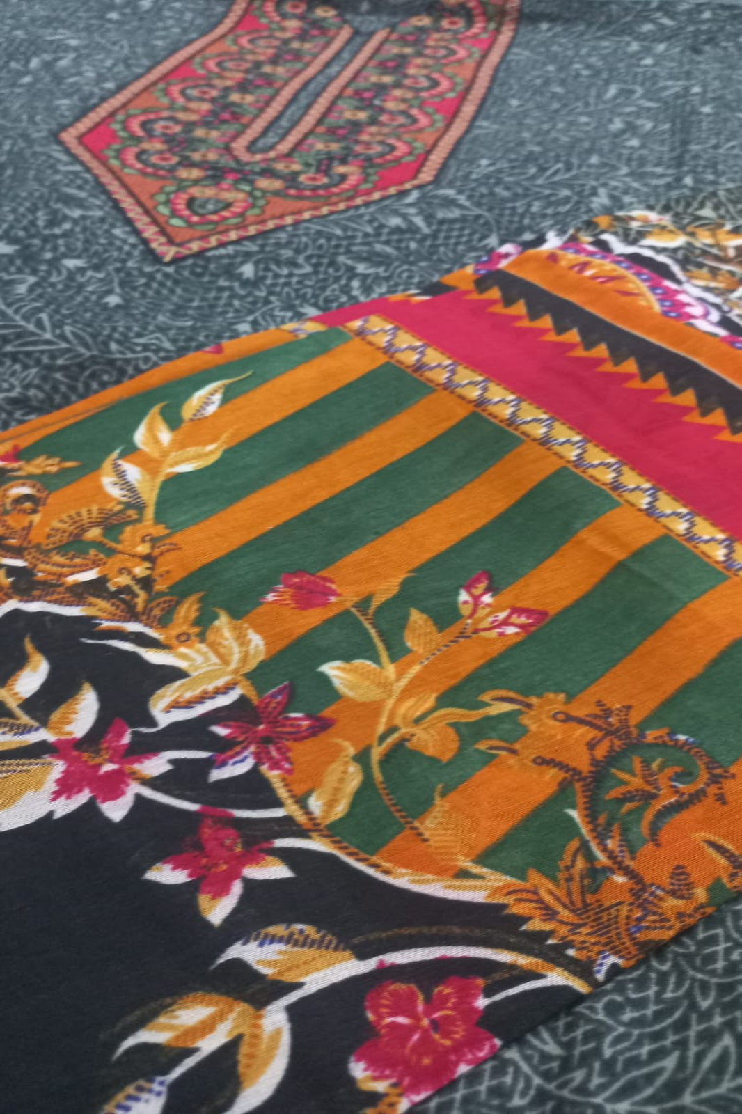 Colorful fabric with floral and geometric patterns on a textured background