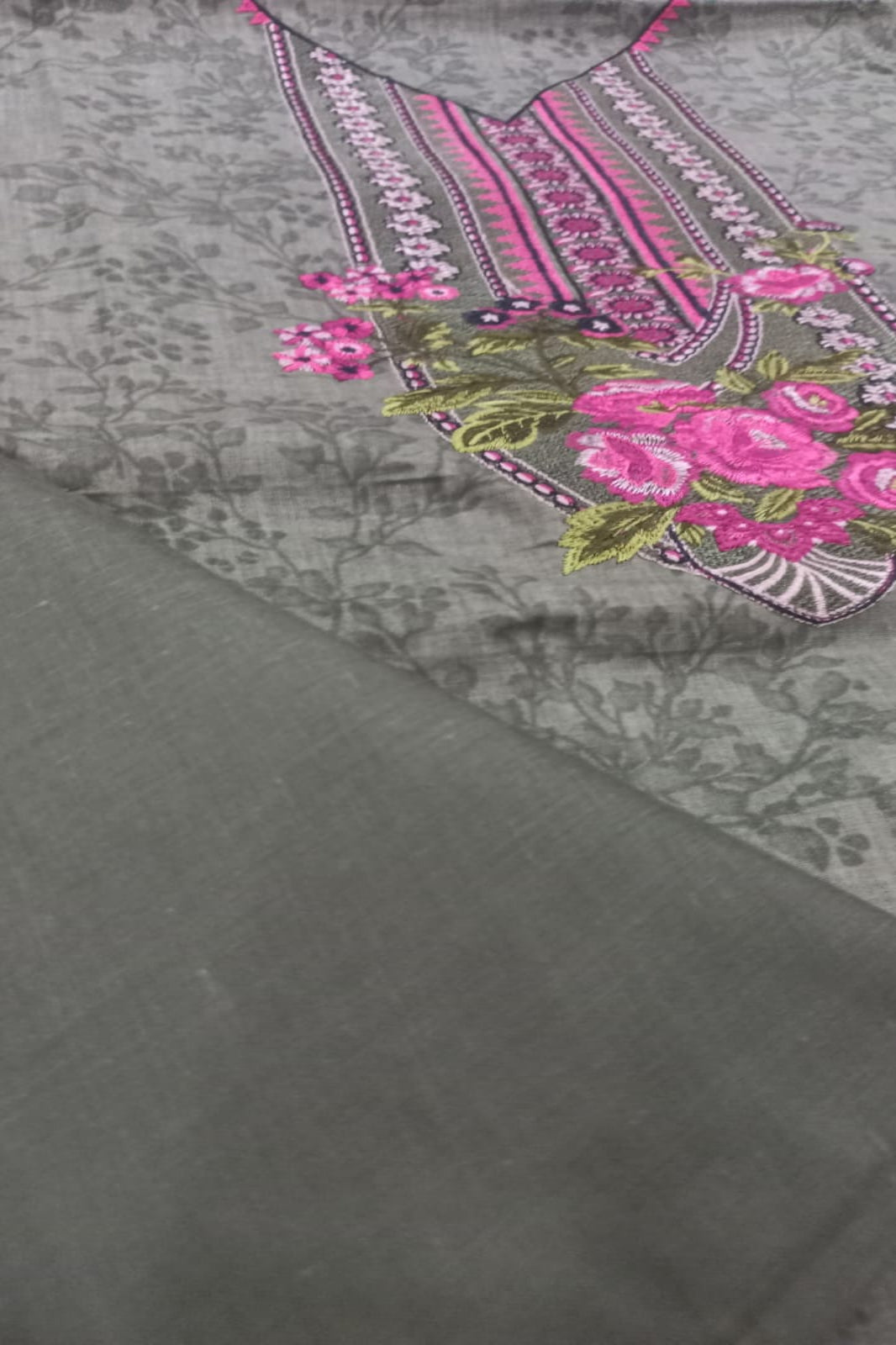 Green fabric with pink floral embroidery