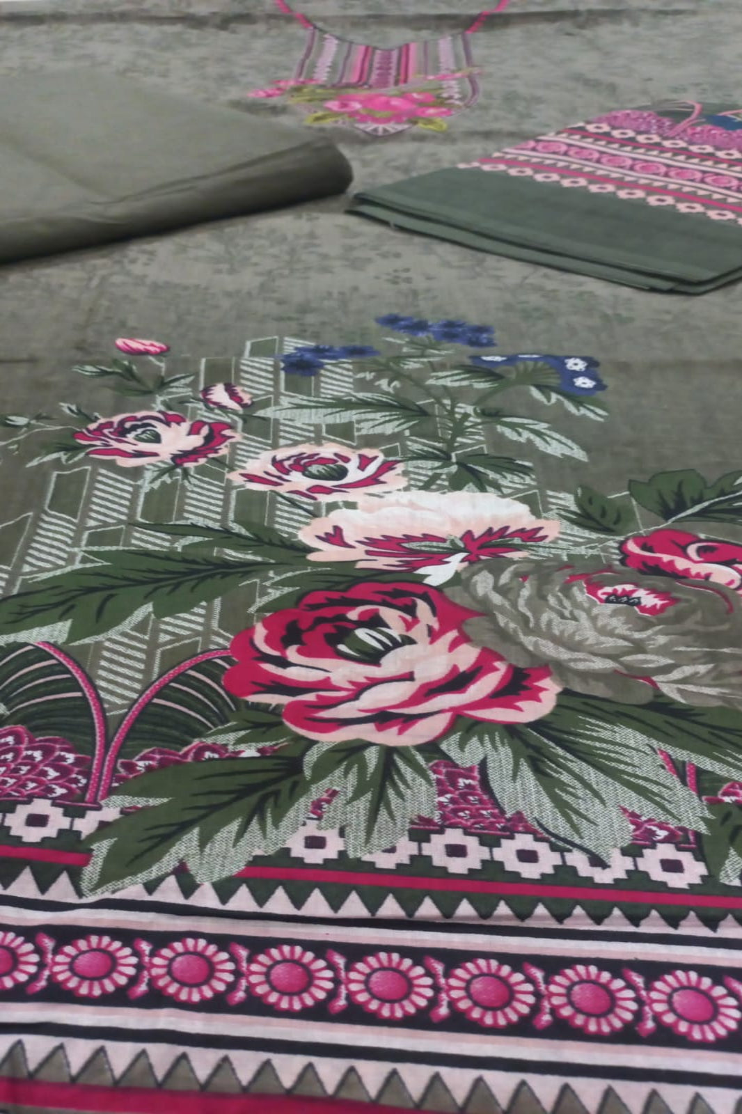 Floral patterned fabric with pink flowers and green leaves on a gray background