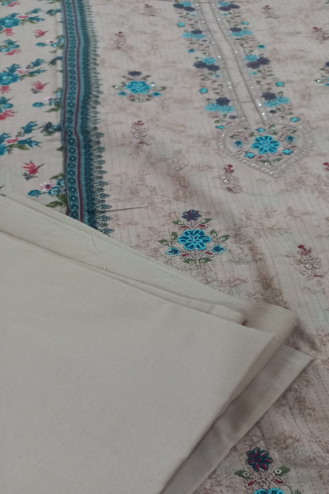 AlZohaib floral patterned fabric with a white sheet on top