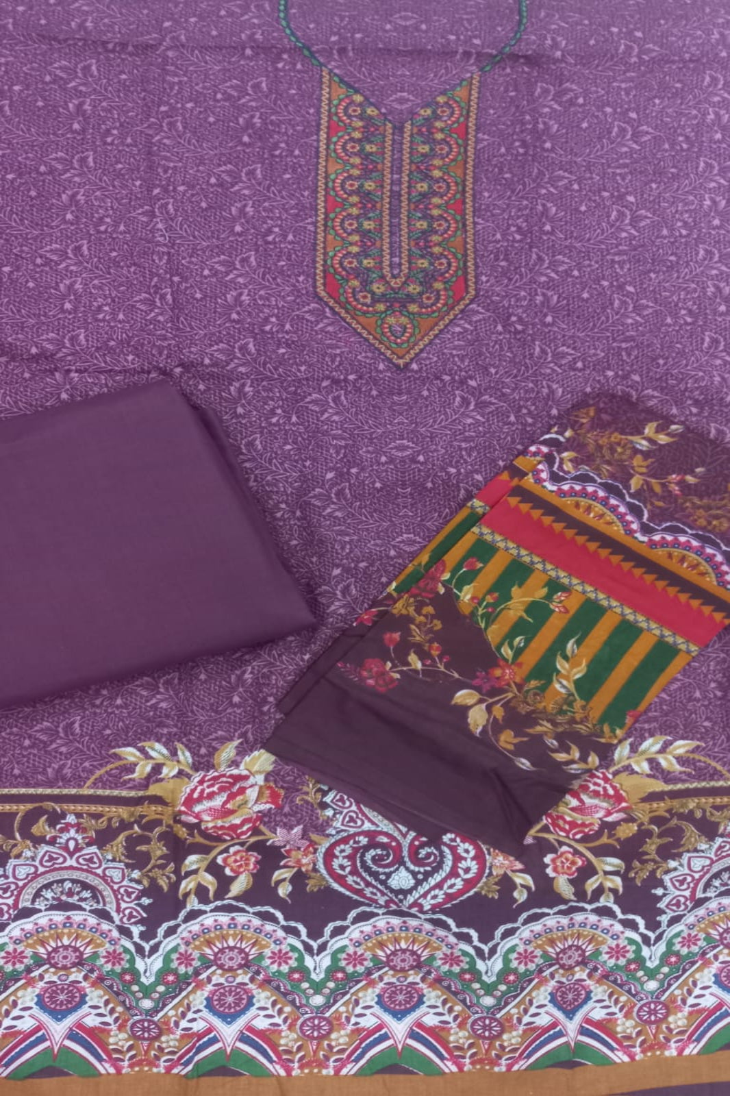 Burgundy  fabric with intricate patterns and a decorative hanging element on a matching background.